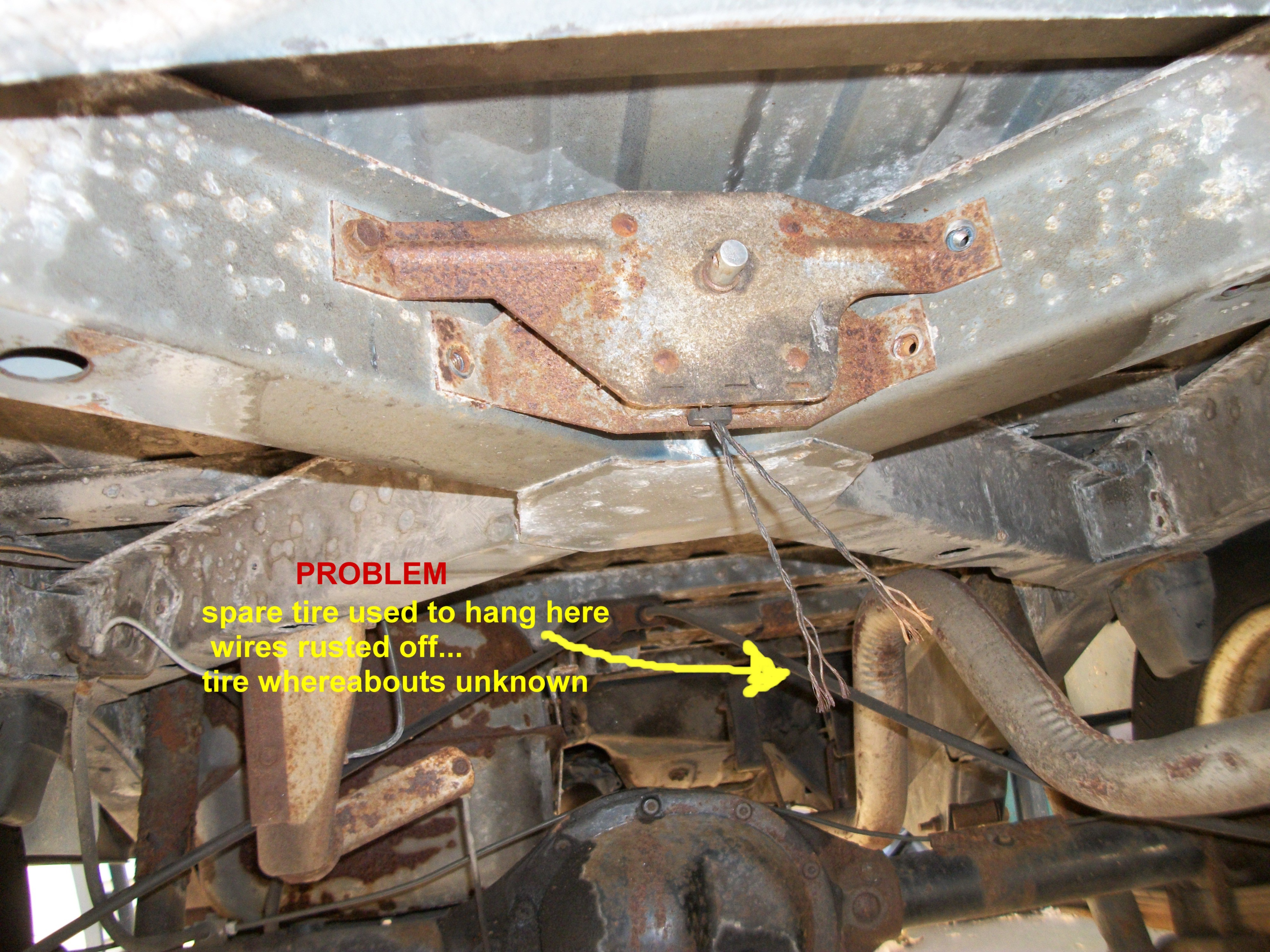 1A PROBLEM wire holding spare rusted off.tire missing.JPG