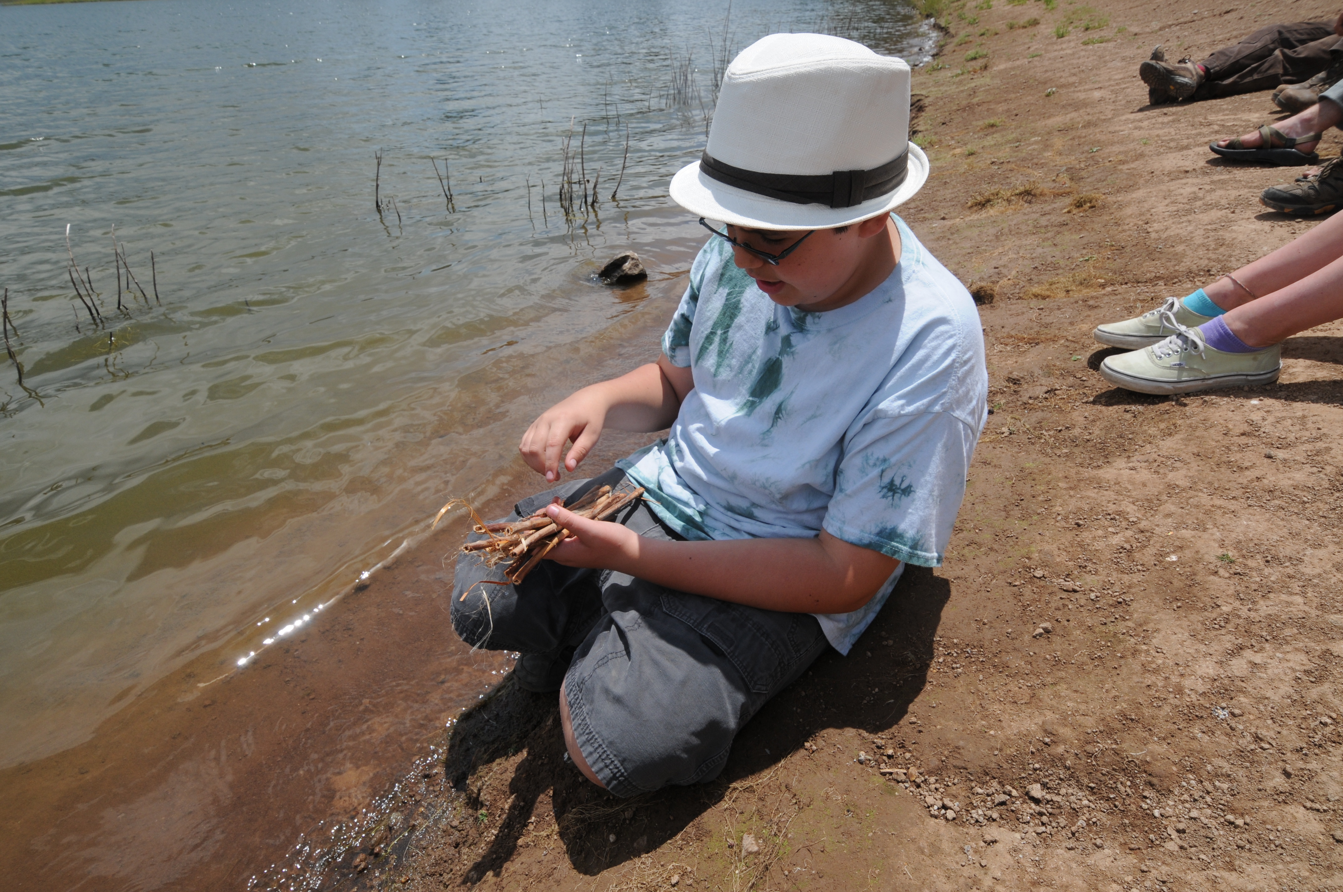 Engaged camper working on cordage for bee nests.JPG