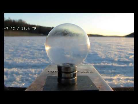 Frozen Soap Bubble on a Levitating and Spinning Magnet