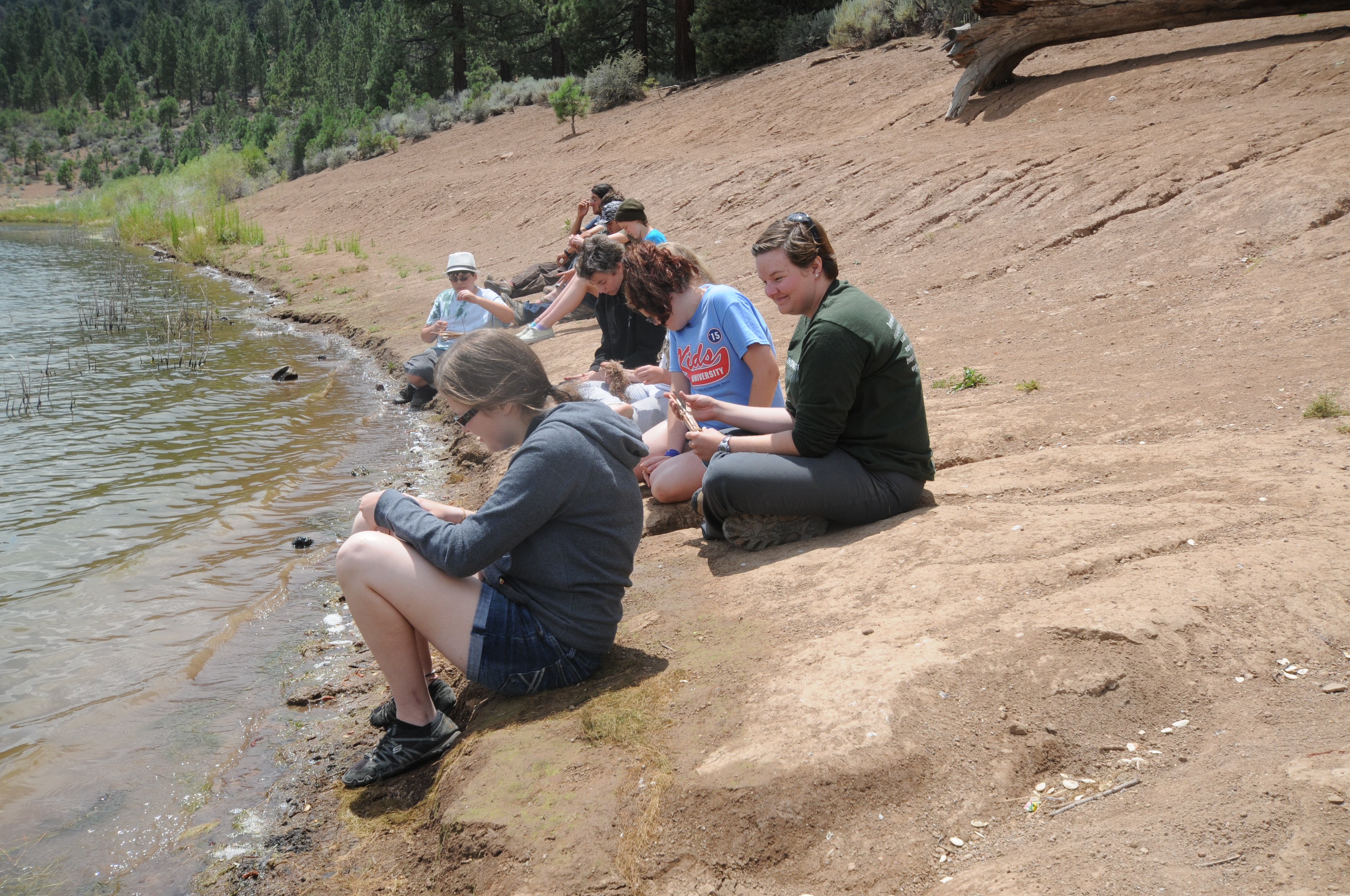 Group of campers near the water to moisten dogbane fibers to make cordage.JPG