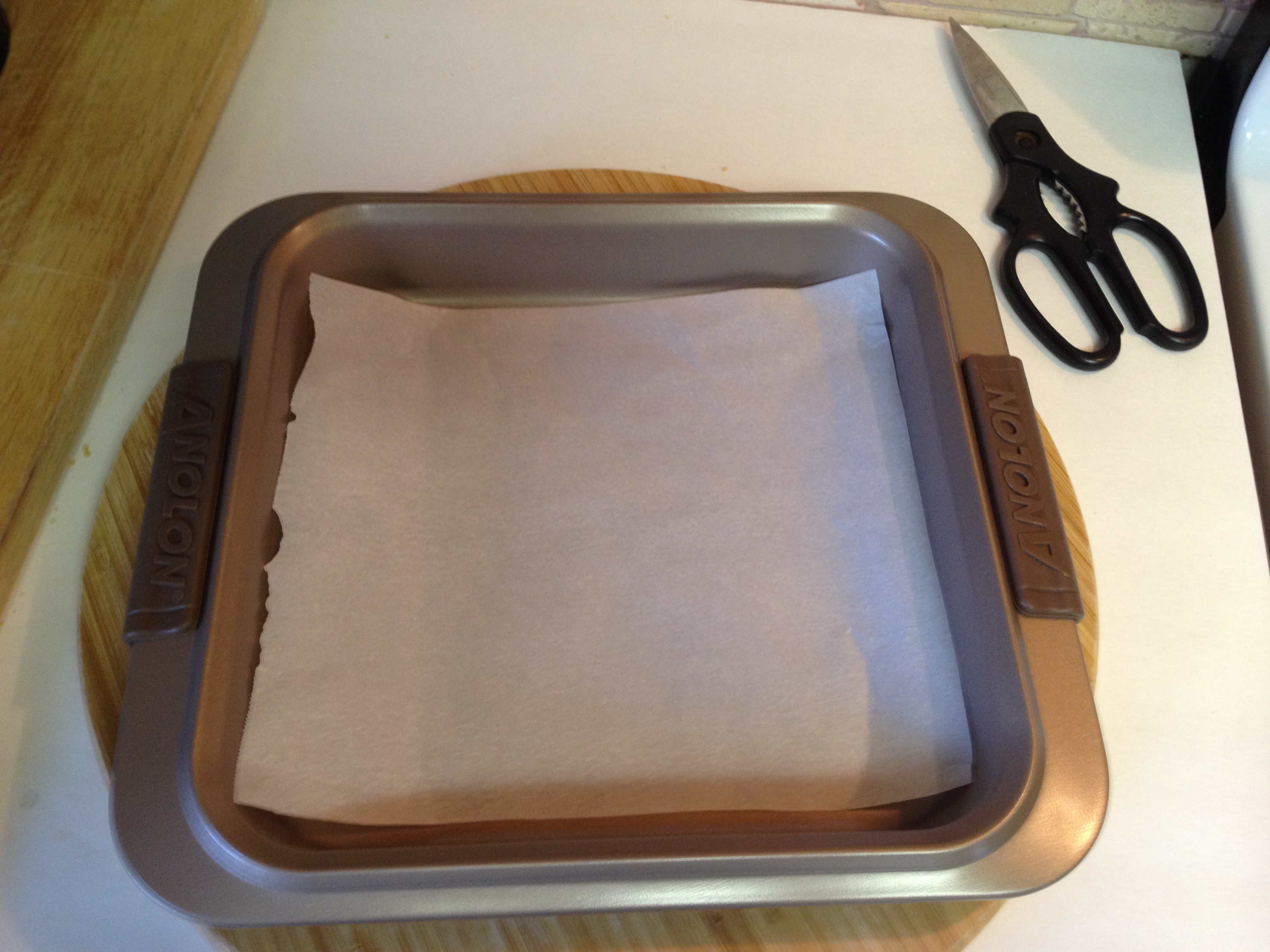 Line buttom 9 inch sq. pan with parchment paper.JPG