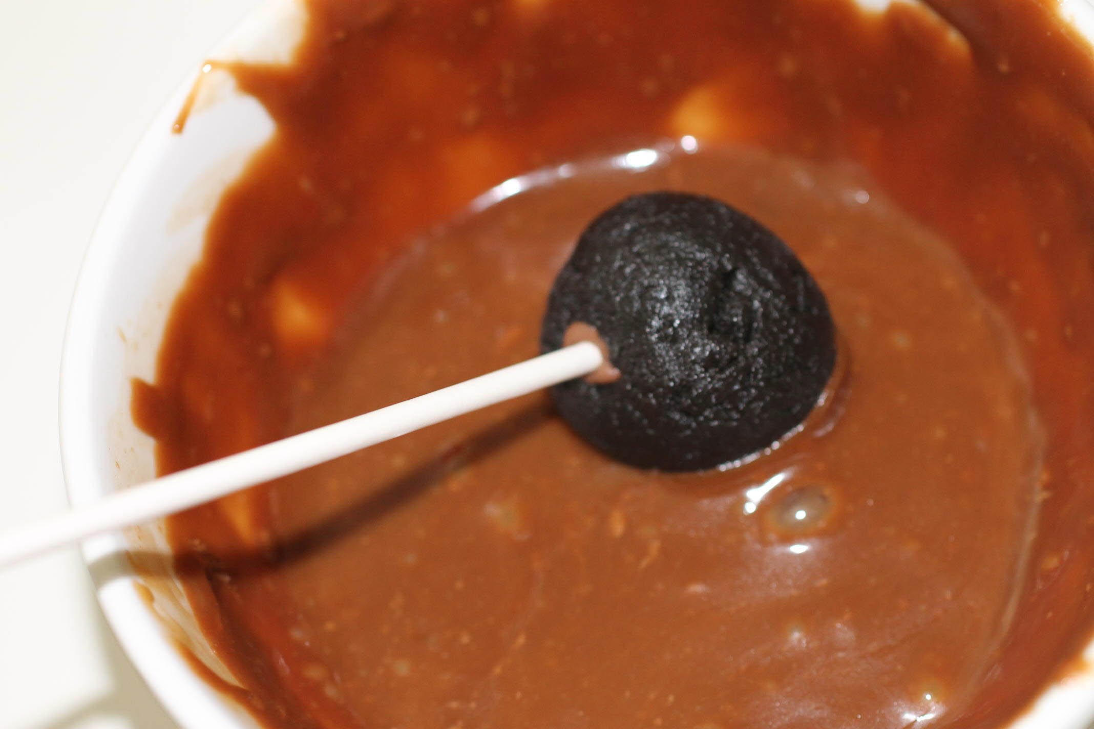 caramel candy oreo cake pops dipping in caramel.jpg