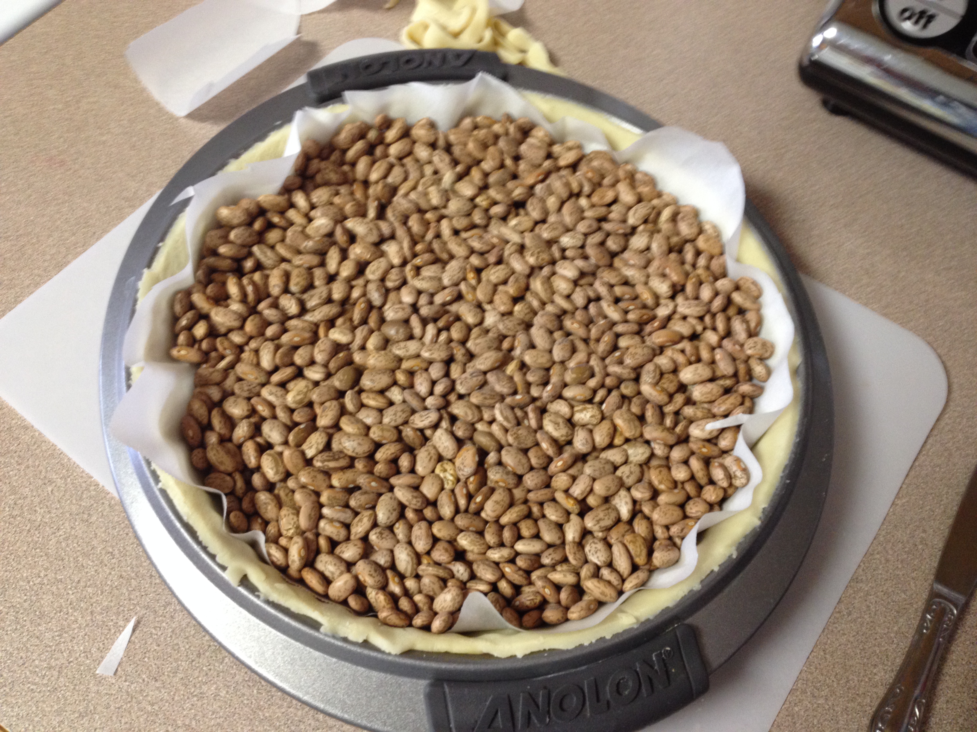 parchment and dried beans placed over crust.JPG