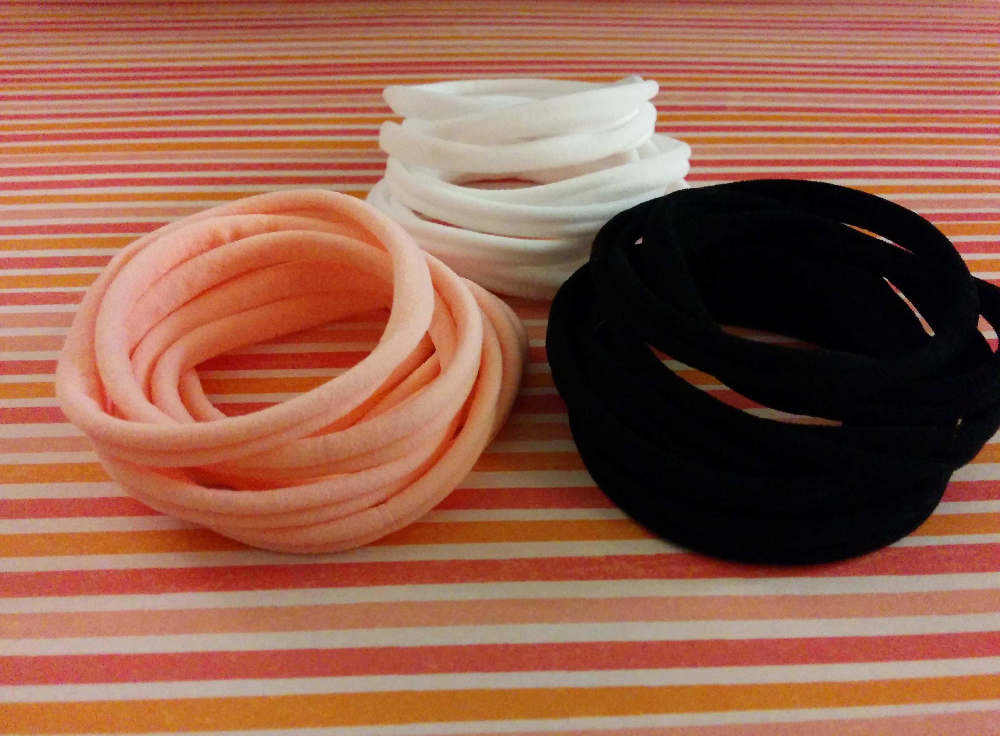 pile of hair ties on pink striped paper.jpg