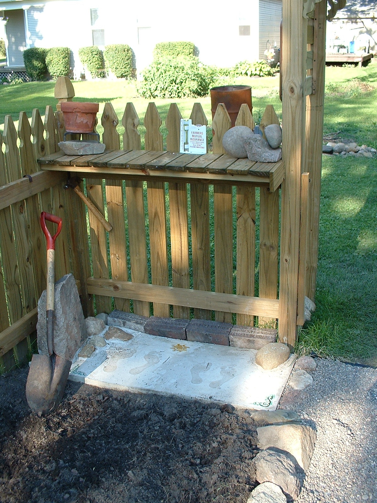 potting bench with foot prints of us &amp; charlie on concrete pad.JPG