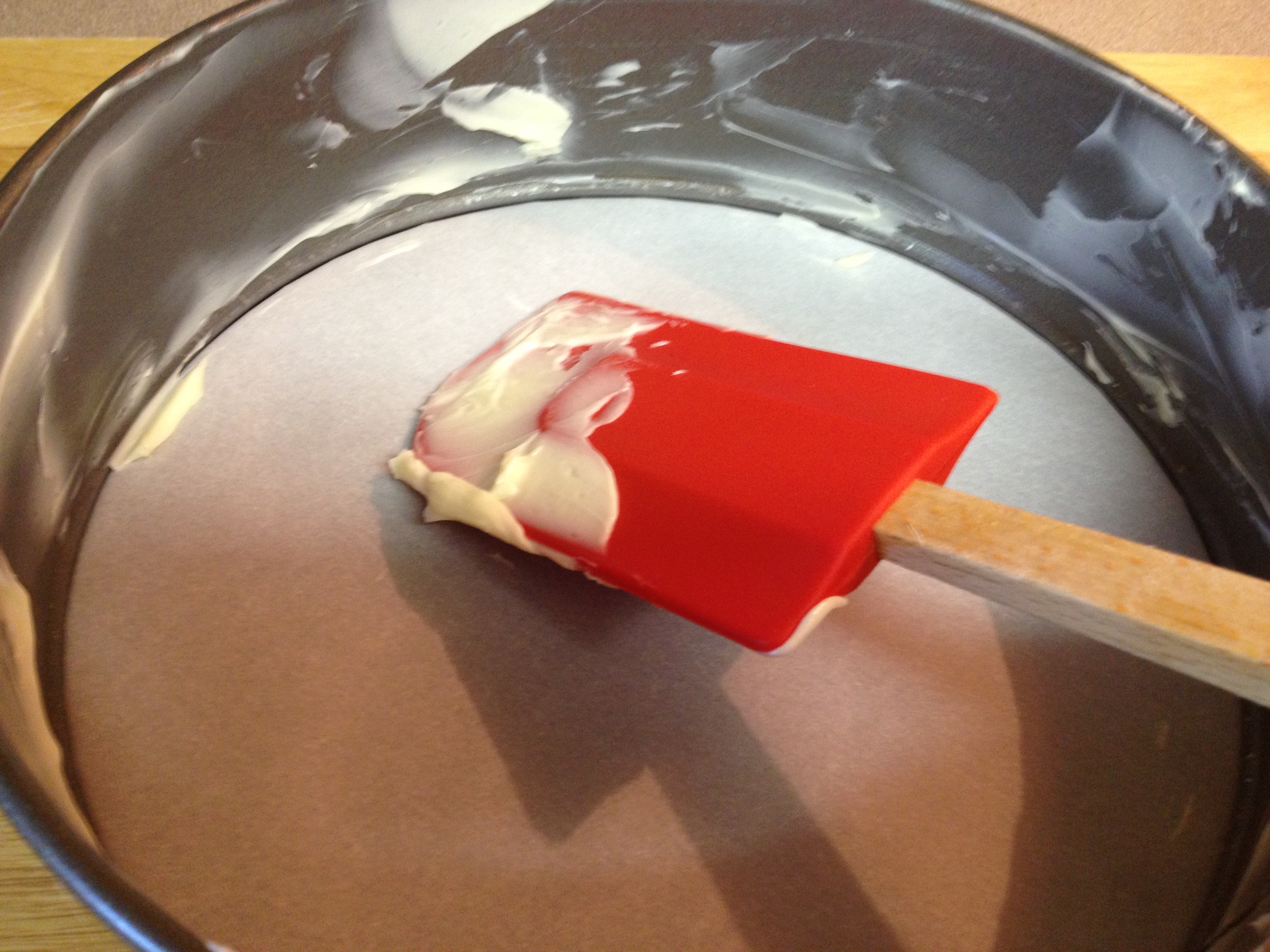 preparing spring-form pan with parchment paper and buttering the sides.jpg