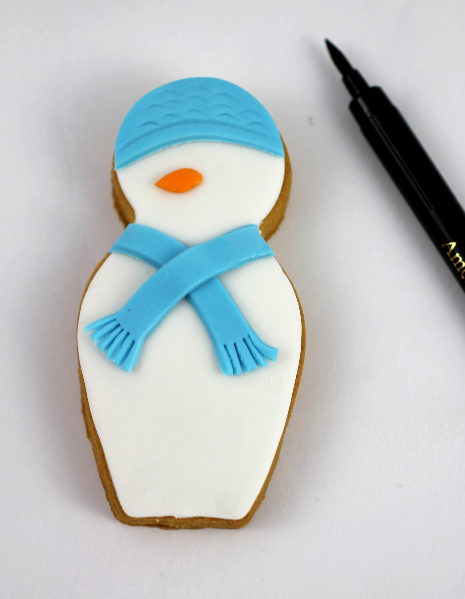 put on a carrot nose and then draw on the eyes and mouth snowman cookie.jpg